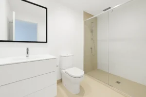 Minimalist bathroom with frameless glass shower, sleek white vanity, and modern fixtures ideal for clean and contemporary renovation projects